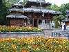 A Buddhist shrine fronted by brilliant flowers on the South Bank of Brisbane, a trendy area of shops, amusements, and restaurants.